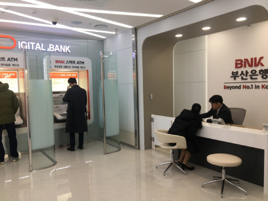 부산은행이 개점한 스마트ATM 기반 디지털뱅크 해운대비치점에서 고객들이 스마트ATM을 통해 금융거래를 하고 있다. 부산은행 제공